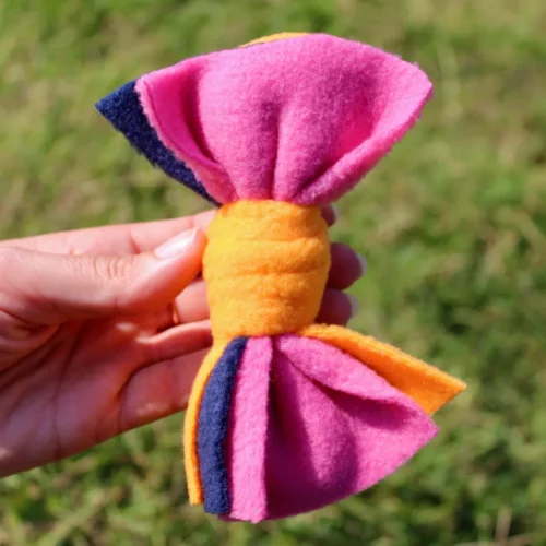 Jouet pour petit chien ou chat tenu dans la main. Noeud rouge et bleu. Fabrication artisanale française.