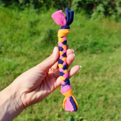 Petite tresse pour chien ou chat tenue dans une main. Ce jouet est spécialement adapté aux petits chiens. Il est fait à la main en France. Couleurs: bleu, orange, rose.