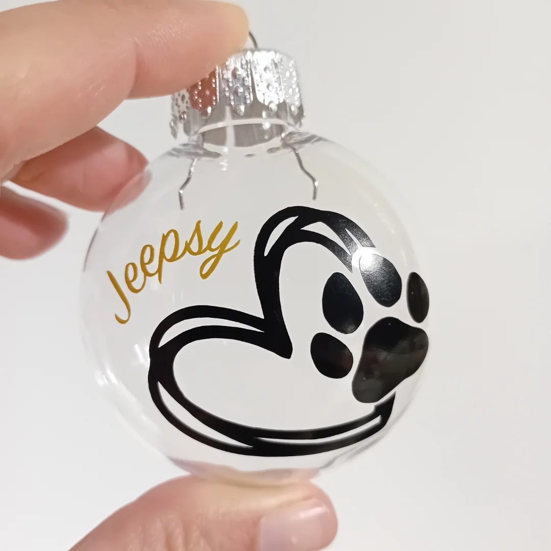 Boule de Noël personnalisée à la main avec une patte, un coeur et le prénom d'un berger allemand.